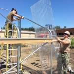 U.S. Navy Petty Officer Second Class Colt Wilson, left, and Petty Officer Joseph Puls attach greenhouse plastic to Crescent Harbor Elementary&rsquo;s new hoop house Wednesday.Photo by Daniel Warn/Whidbey News-Times