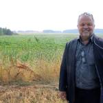 Photo by Jessie Stensland / Whidbey News-Times                                Oak Harbor resident Scott Thompson stands in front of a cornfield that his development group has proposed turning into a large affordable-housing project.