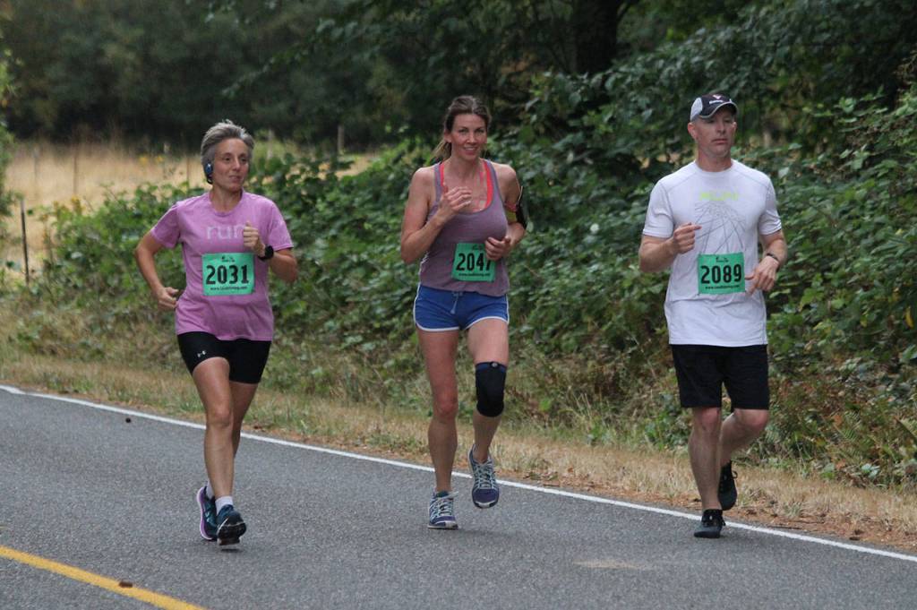 Patty Hengel, left, Melissa Kmetz and Ryan Terpening get back on the road after a trip through Rhododendron Park. (Photo by Jim Waller/Whidbey News-Times)