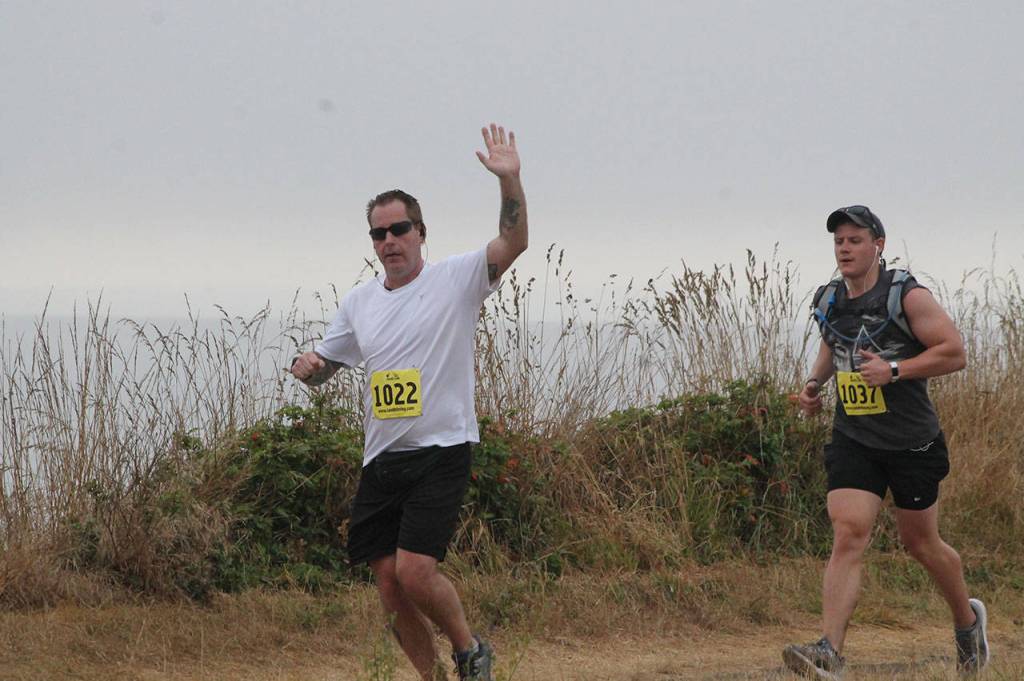 Brent Johnston, left, has a high-five for the photographer. He is joined on the bluff trail by Robert Stone. (Photo by Jim Waller/Whidbey News-Times)