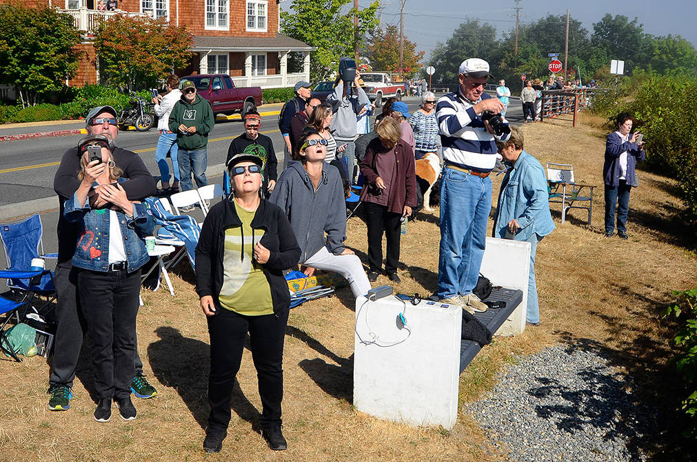 Justin Burnett / The Record &mdash; A crowd of people are wowed near the peak eclipse Monday morning.