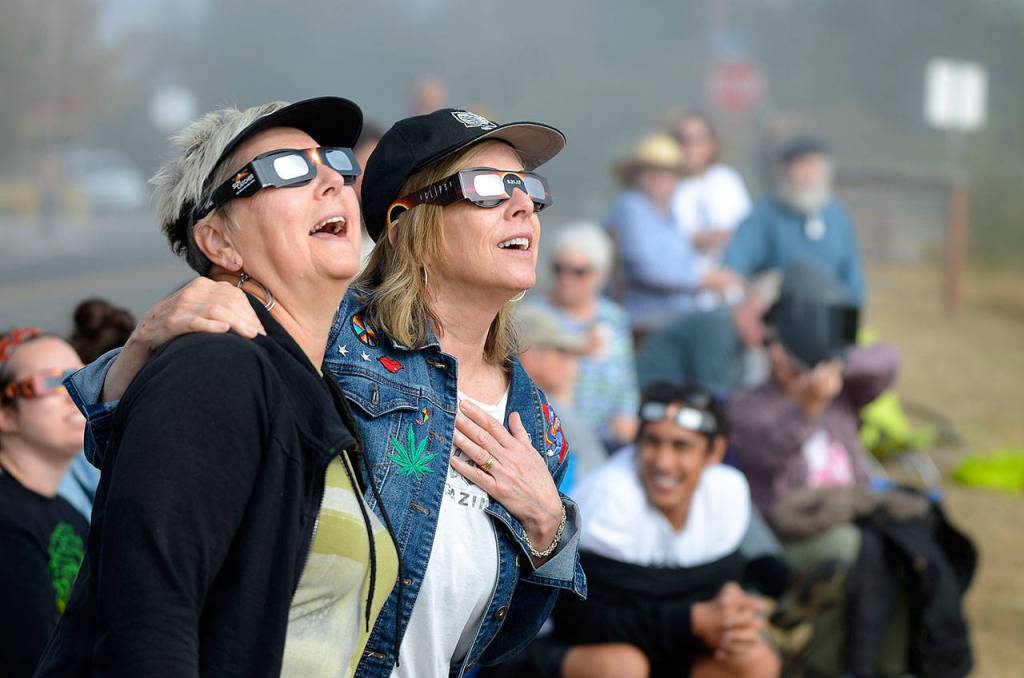 Justin Burnett / The Record &mdash; Langley residents Nancy Loorem Adams (left) and Debbie Loudon (right) sing along to Bonnie Tyler&rsquo;s &ldquo;Total Eclipse of the Heart&rdquo; during Monday&rsquo;s partial solar eclipse.