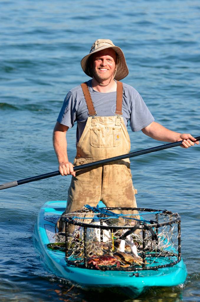 Justin Burnett / The Record &mdash; Stewart chose to drop and collect his crab pots with a paddleboard after realizing it was quicker and more environmentally friendly.