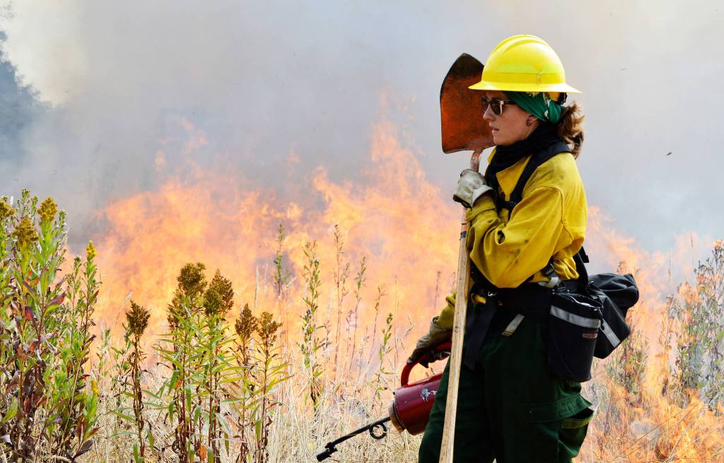 Michelle Boderck, from the Center for Natural Lands Management, assists Thursday with a controlled burn at the Admiralty Inlet Natural Area Preserve. The burn is part of the Whidbey Camano Land Trust&rsquo;s effort to restore prairie lands on the island. Photo by Laura Guido/Whidbey News-Times