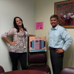Christin McCausland (left) and Emmanuel Montenegro stand next to one of the donation boxes for SeaMar Community Health Center&rsquo;s blanket and clothing drive. Photo provided by SeaMar