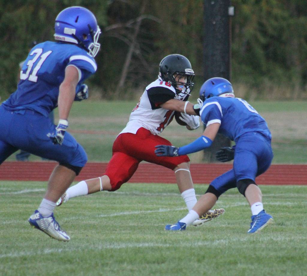 Coupeville&rsquo;s Shane Losey fights off the tackle of Bodie Hezel (8) as Clay O&rsquo;Brien (31) races in to help. (Photo by Evan Thompson/Whidbey News Group)