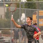 William Nelson hits an overhead smash in his win with Joey Lippo in first doubles. (Phboto by John Fisken)