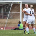 Lauren Bayne celebrates her long-distance goal with Avalon Renninger (16) as the Bellevue Christian goalkeeper can only look at the ball in the net. (Photo by John Fisken)