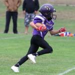 Jesus Holden looks for yardage for the Oak Harbor Juniors. (Photo by John Fisken)