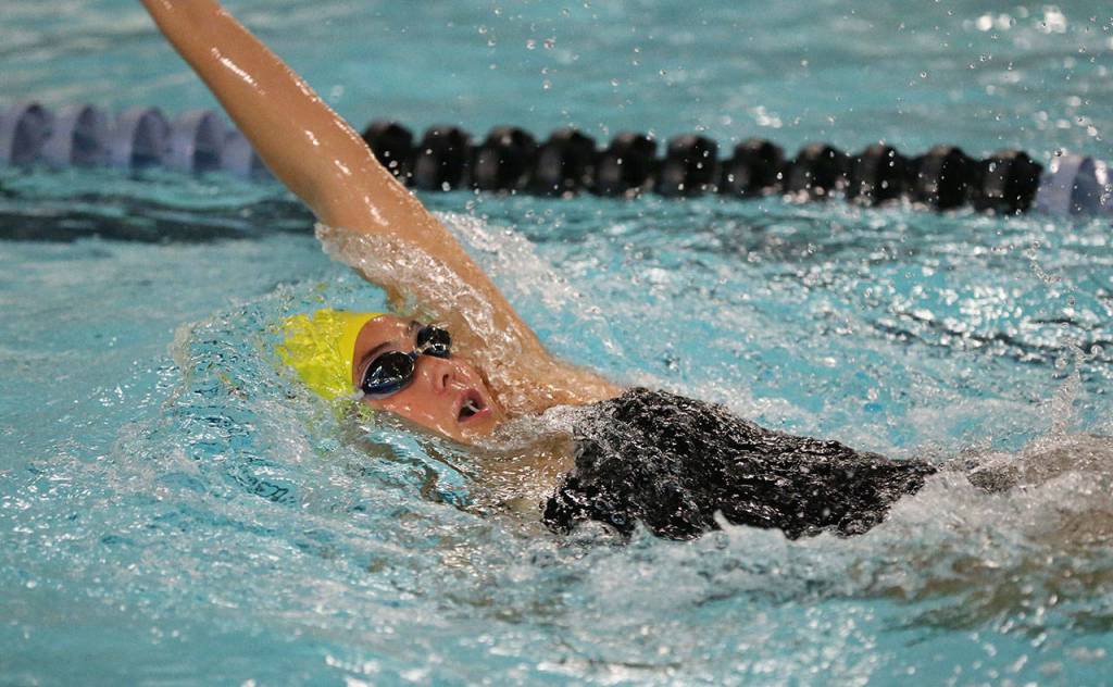 Oak Harbor&rsquo;s Olivia Tungate zips to an easy win in the 100-meter backstroke. (Photo by John Fisken)