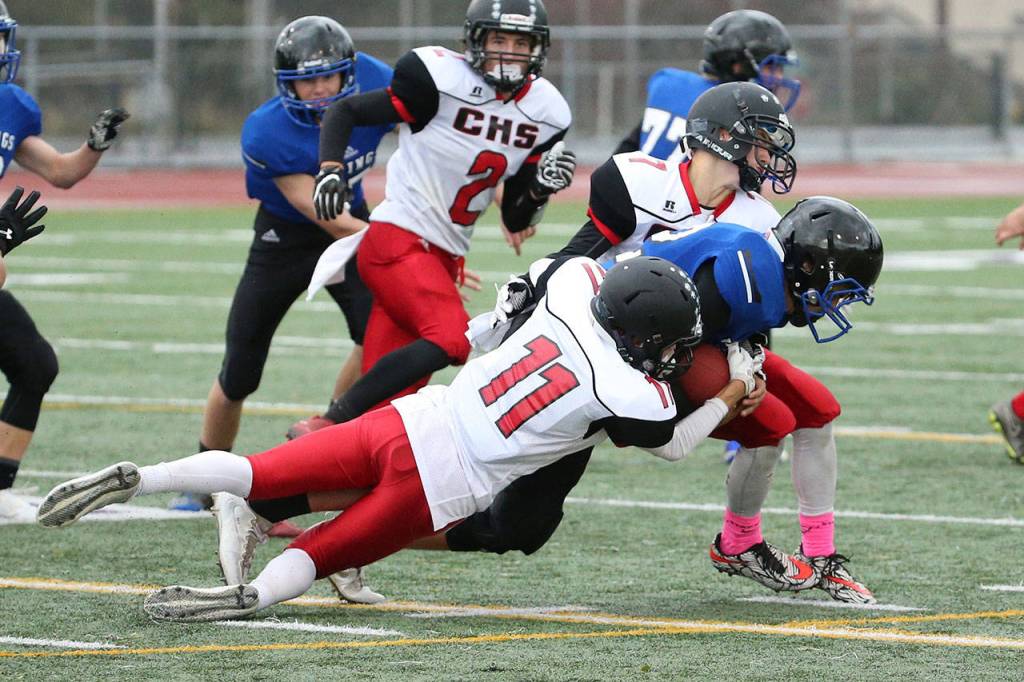 Cameron Toomey-Stout (11) has developed into a two-way starter for the Wolves. Above, he helps bring down a Bellevue Christian ball carrier last fall. (Photo by John Fisken)