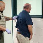 Photo by Jessie Stensland / Whidbey News-Times                                Corrections deputies Pam McCarty and Gerald Adams process a man during a booking Thursday morning at the Island County Jail.