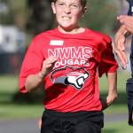 Alex Merrill edges a Burlington-Edison runner for third place in the seventh-grade boys race. (Photo by John Fisken)
