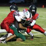 Matt Hilborn, left, and Jake Hoagland team-up to bring down Charles Wright&rsquo;s Asher Shakoor-Asadi. (Photo by Jim Waller/Whidbey News-Times)