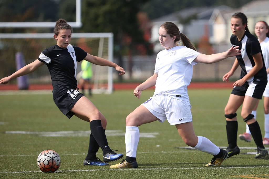 Peyton Rhyne and South Whidbey&rsquo;s Karyna Hezel (12) battle for control of the ball. (Photo by John Fisken)