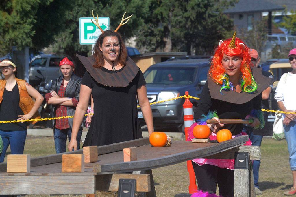 Windermere team member Sarah Erbe, right, tries to sink a pumpkin while team mate Cheryl Lueder cheers on. Photo by Megan Hansen/Whidbey News-Times