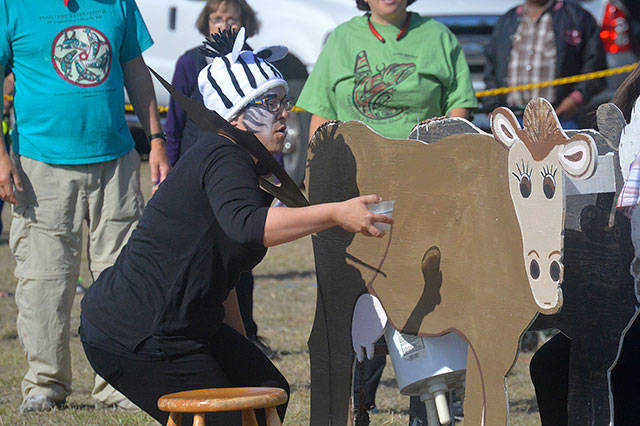 Jacklyn Allen with the Windermere team hands off a container to the judge to see if she&rsquo;d milked enough from &ldquo;Bessie.&rdquo; Photo by Megan Hansen/Whidbey News-Times