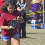 Jackie Contreras with the Penn Cove Water Festival team heads toward the finish line carefully balancing a raw egg on a spoon. Photo by Megan Hansen/Whidbey News-Times