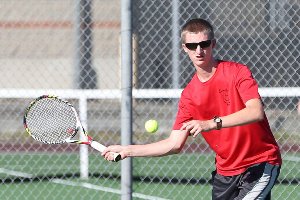 The Wolves&rsquo; Jakobi Baumann swats a shot in his sweep of second singles. (Photo by John Fisken)