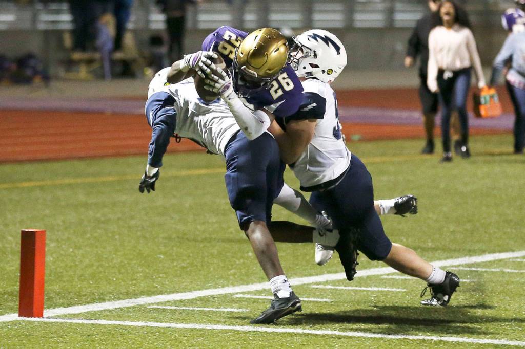 In the next four photos, Oak Harbor&rsquo;s TJ Hollins-Passmore splits two defenders to score the tying touchdown.(Photos by John Fisken)