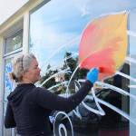 Stephanie Fries transforms Pioneer Way shop windows into swirling images of fall colors. She used some of the design she&rsquo;d previously created for the Oak Harbor Music Festival. Photos by Patricia Guthrie/Whidbey News-Times