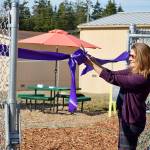 Kellie Tormey, former Oak Harbor Public Schools Communication Officer, cuts the ribbon on Crescent Harbor&rsquo;s garden Wednesday afternoon. Tormey was responsible for procuring the grants for the garden and the school&rsquo;s new covered play structure, both which were unveiled at Wednesday&rsquo;s event. Photo by Laura Guido/Whidbey News-Times