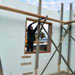 Nevin Miranda of Viewridge Construction installs a window frame on a new house being built on Leach St NE. The county recently released a survey to determine residents&rsquo; satisfaction with housing in Island County. Photo by Laura Guido/Whidbey News-Times