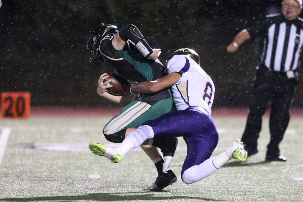 Darian Matsushita tackles Marysville Getchell quarterback Caleb Koellmer. Matshuita and the Wildcat defense limited the Chargers to only 104 yards of offense.(Photo by John Fisken)