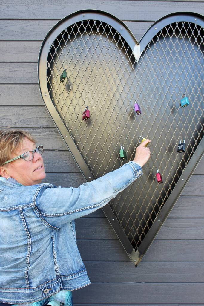 Therese Kingsbury shows &ldquo;The Heart of a Soldier&rdquo; on the side of The Loft building. Locks are attached that honor military members. It was built at CNB Iron Works Construction.