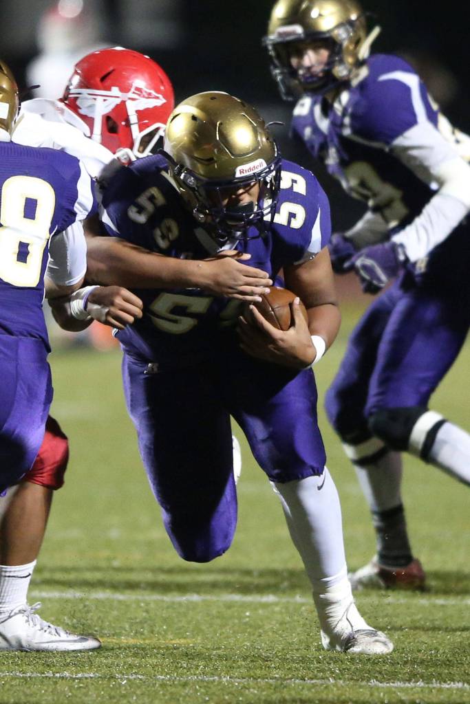 Oak Harbor&rsquo;s Kamren Mebane (59) bulls ahead after catching a tipped pass.(Photo by John Fisken)