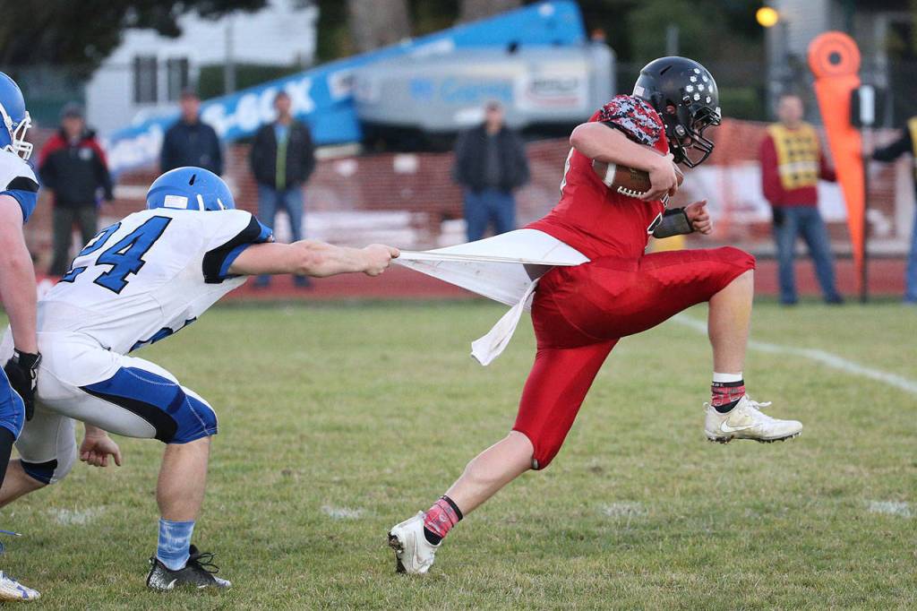 Above and in the photo below, Coupeville&rsquo;s Hunter Downes slips out of the grasp of Chimacum&rsquo;s Ryan Caldwell.(Photo by John Fisken)