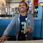 Geno Dogans shows the camera his &ldquo;E.T.&rdquo; finger as he stands behind the counter at Thrive Community Fitness. He uses his amiable personality to make customers feel welcome as they walk in; he got his job there through the county&rsquo;s work program for adults with developmental disabilities. Photo by Laura Guido/Whidbey News-Times