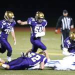 Isaac Gomez tackles Brennan Holmes for a loss as Hunter Bos (75), Michael Fisken (54) and TJ Hollins-Passmore (26) close in. (Photo by John Fisken)