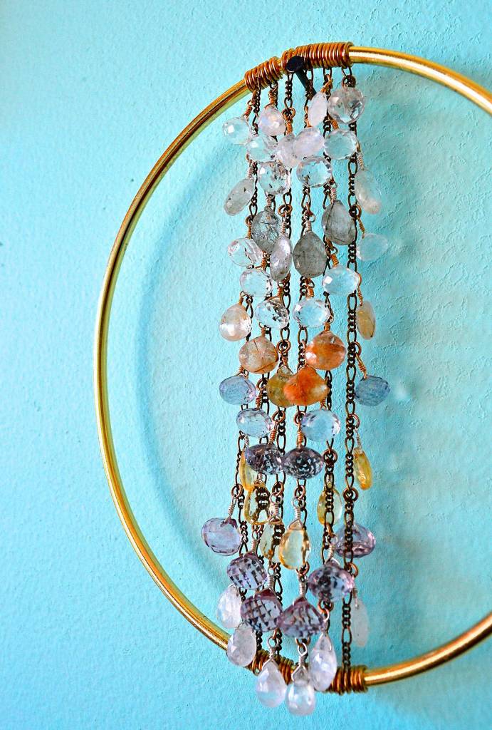 Alexa Allamano photo  Allamano makes home decor in addition to jewelry. In this piece, 52 gemstones are tethered to vertical chains and suspended in the center of a brass oval.