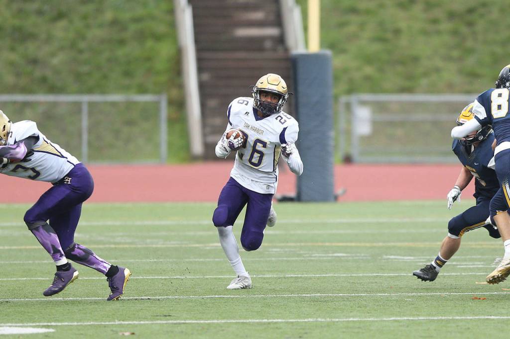 TJ Hollins-Passmore (26) heads up field after getting a block from Andrew Miller (3). (Photo by John Fisken)