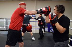 Kyle Jensen / The Record  Clinton resident Steve Burr works with trainer Lauren Coleman on the punch mitts.