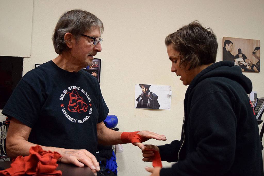 Kyle Jensen / The Record  Trainer Lauren Coleman helps boxer Ed Wootten apply hand wrap to protect his knuckles.