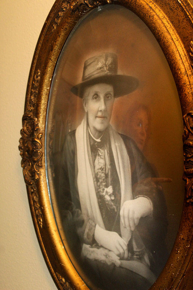 Jacqueline Vannice is reflected in the sepia-toned photograph of her relative, Emily Jane (Newey) Barnes, born in Kenilworth, Warwickshire, England to a family of comb makers. Photo by Patricia Guthrie/Whidbey News-Times