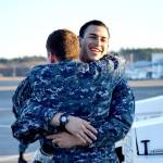 Jose Kuder, petty officer third class, is welcomed back by JJ Hughes during the homecoming for electronic attack squadron 142 Tuesday. Photo by Laura Guido/Whidbey News-Times