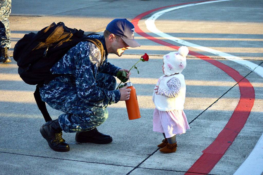 A sailor greets his baby after returning Tuesday from a six-month deployment with Electronic Attack Squadron 142. Photo by Laura Guido/Whidbey News-Times