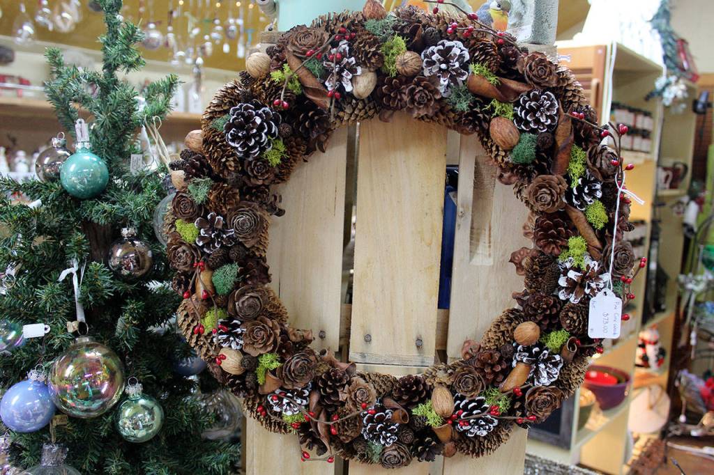 This wreath is packed with pinecones with other natural touches. Wreaths for all seasons are made by A Knot in Thyme artist and employee Tressa Green, including ones with seashells and dried flowers. Wendy Rawls challenged her to try a new design using all things pines. She said, Oh I know you can do it, Green said. And it came out really well.