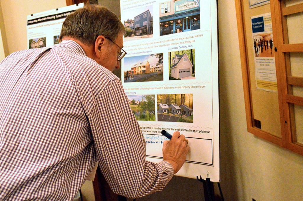 John Mishasek, a Port of Coupeville commissioner, writes in a comment on the recommendations put forth by the North Whidbey Affordable Housing Task Force. The open house Thursday night provided an opportunity for the pubic to ask questions, submit comments and answer questionnaires about the task forces ideas. Photo by Laura Guido/Whidbey News-Times