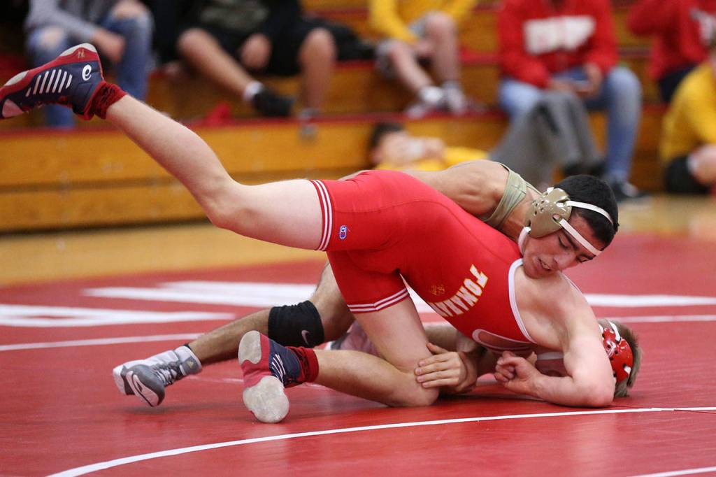 Caleb Fitzgerald, top, works to keep control of M-Ps Austin Davis.(Photo by John Fisken)