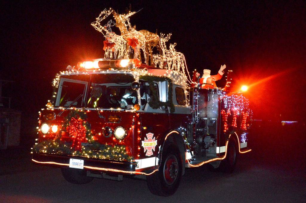 Santa waves from atop Central Whidbey Fires Santamobile Wednesday night. CWIFR Commissioner Paul Messner has been participating in this tradition for almost 30 years. Photo by Laura Guido/Whidbey News-Times