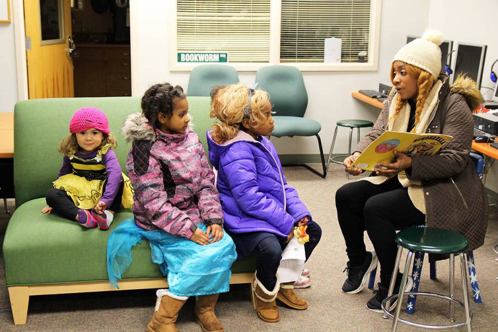 Lelia Brown reads to (from left) Faith, Chanel and Aubrey Brown during Broad View Elementary Schools Literacy Night Thursday. Students and teachers were encouraged to dress up to match the fairy tale theme of the evening. Photo by Laura Guido/Whidbey News-Times