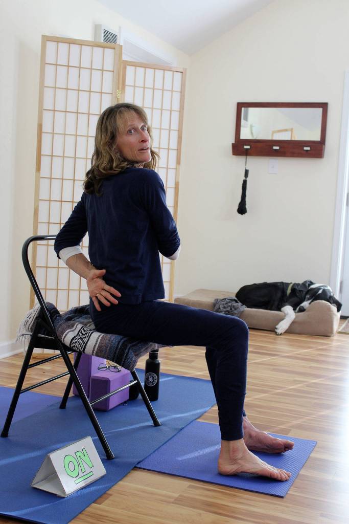 Renee Le Verrier teaches an online yoga class for people with movement disorders from her studio in Oak Harbor. In the background taking a nap is her service dog, a Great Dane named Tommy. Photo by Patricia Guthrie/Whidbey News-Times