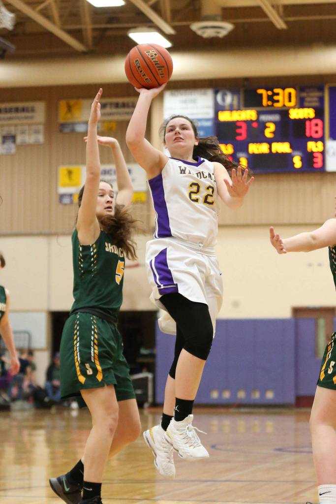 Mia Littlejohn floats by Shorecrests Amanda Lee (5) on the way to the hoop.(Photo by John Fisken)