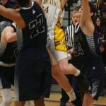 Oak Harbors Kevin Schuldt splits Arlington defenders Ayodele Aribibola (22) and Josh Gutierrez on the way to the hoop. (Photo by Jim Waller/Whidbey News-Times)