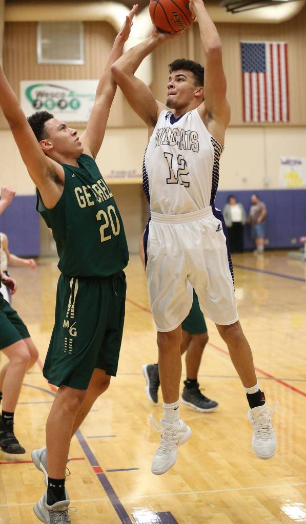 Oak Harbors Ozell Jackson (12) shoots over the attempted block of Ethan Jackson.(Photo by John Fisken)