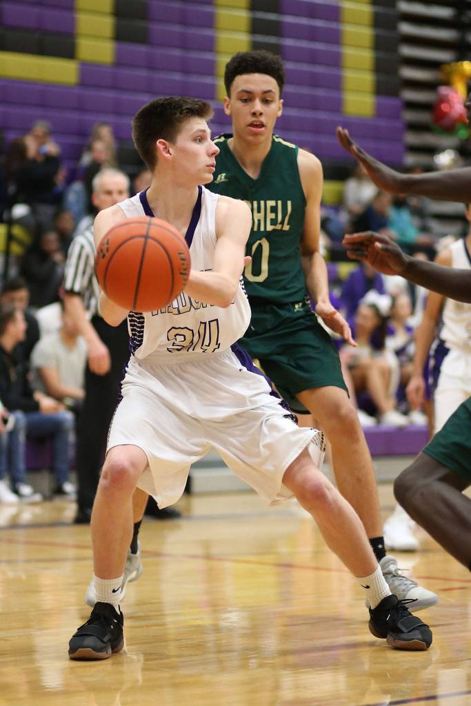 Oak Harbors Kevin Schuldt, who led the Wildcats with 12 points, passes out of a Charger trap.(Photo by John Fisken)